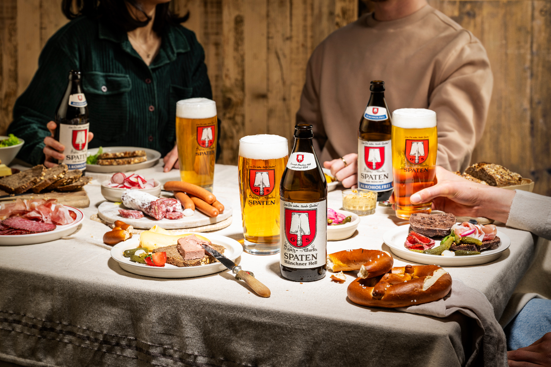 Gedeckter Tisch mit Spaten Bier, Brezn, Wurst und Brotzeit im Festzelt-Ambiente